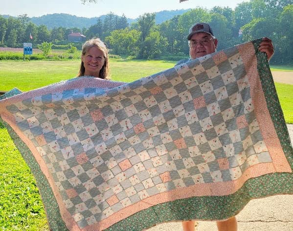 Chaseburg Area Cancer Walk volunteers holding a quilt